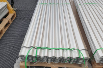 Stacked 29-gauge corrugated galvanized steel panels in a Lake Stevens warehouse, showing the clean aluminum-zinc coating and consistent rib profile ready for local pickup.