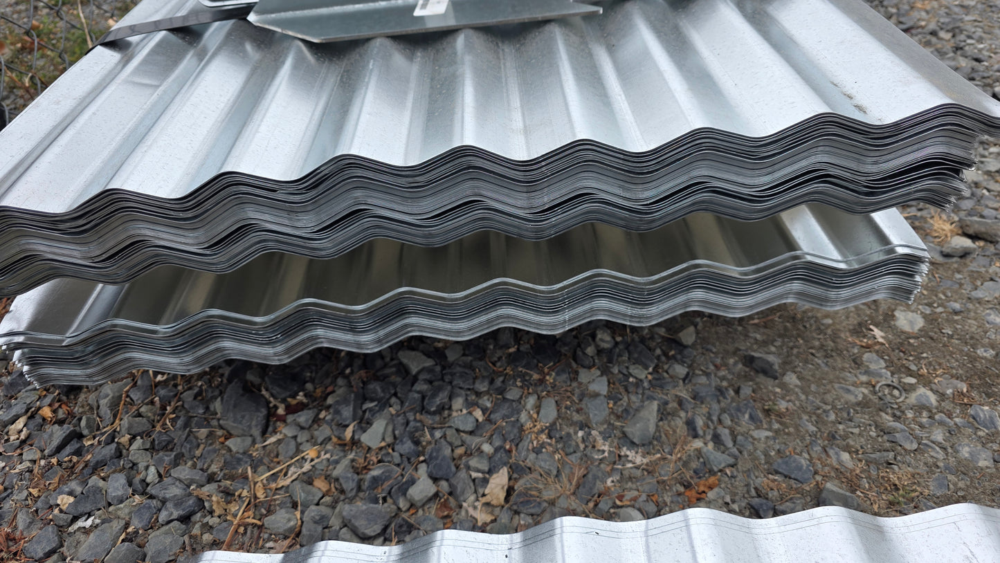Stack of corrugated metal roofing sheets on a gravel surface