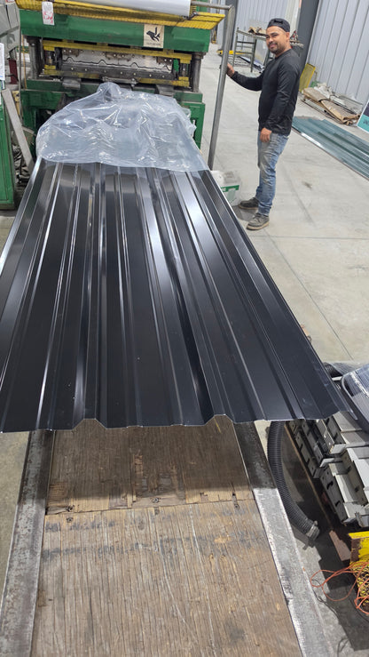 Large metal panel on a wooden platform with a person in the background.